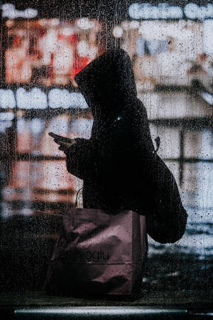 Young Woman Stepping Out Into A Rainy Day Wallpaper