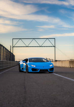 Zoom Past The Competition With A Stylish Blue Lamborghini. Wallpaper